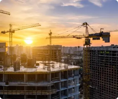 Construction cranes at sunset