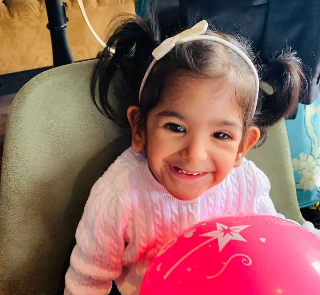 Avanya smiling and holding a pink balloon