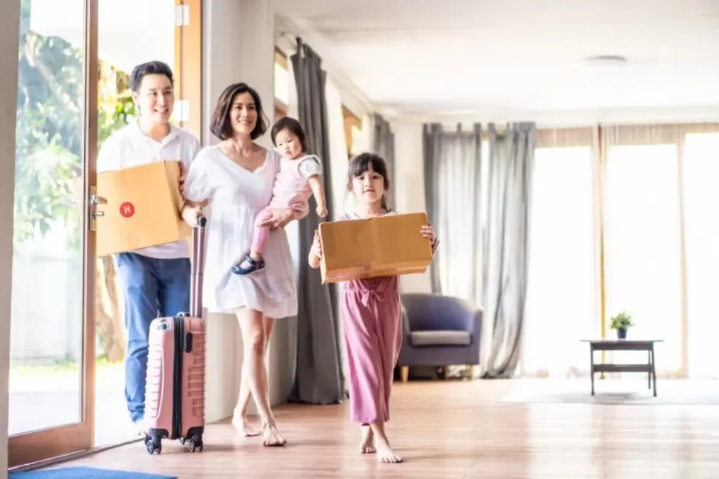 Family carrying boxes into their new home